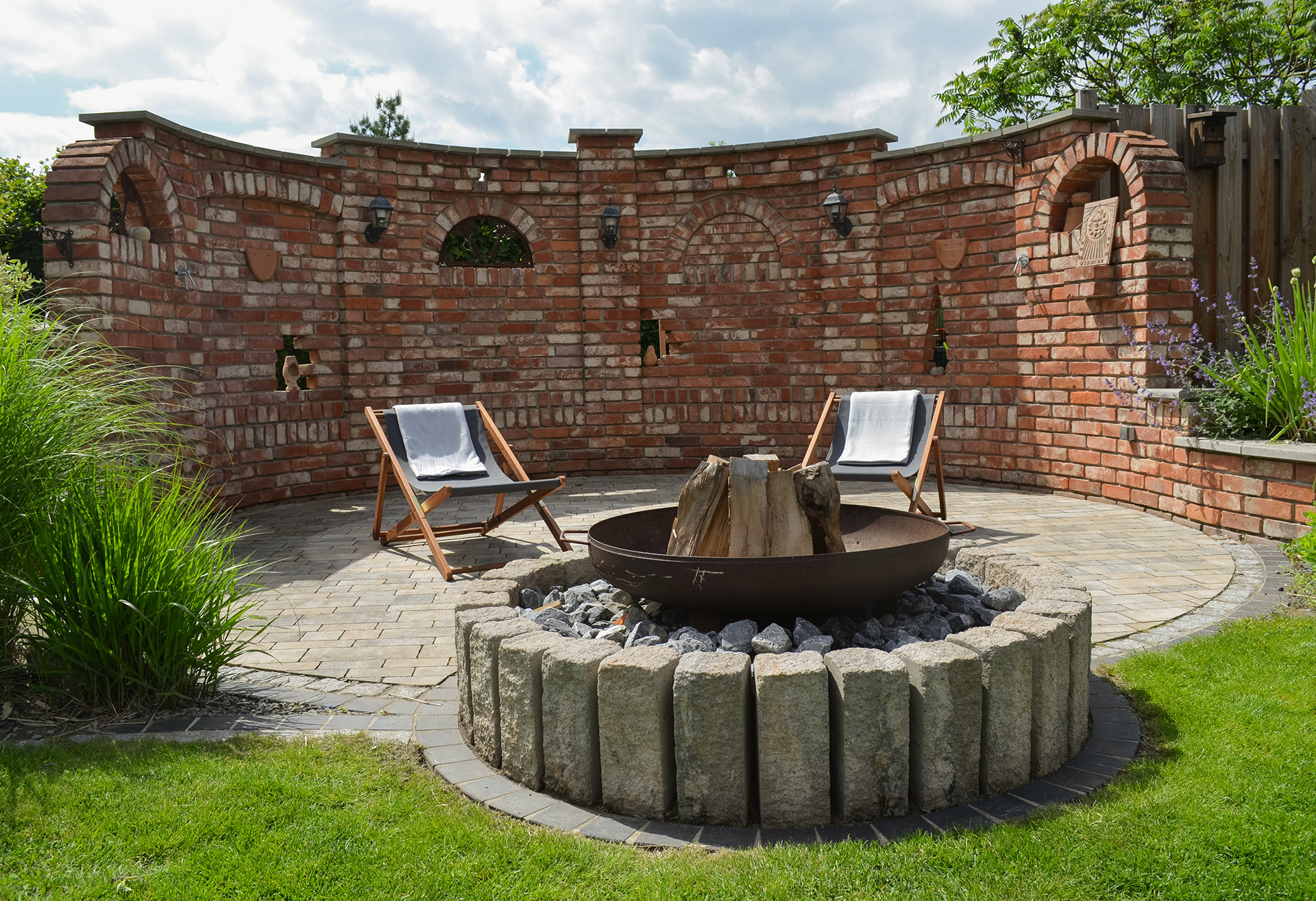 Moderne Gartenanlage mit Natursteinen und Feuerstelle